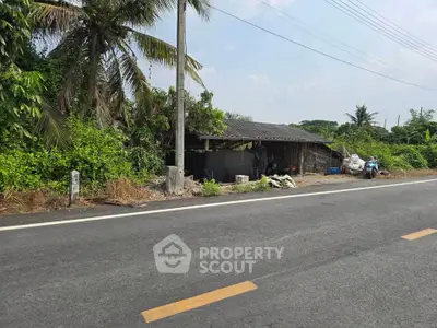 Rural roadside property with rustic charm and lush greenery, ideal for development or agricultural use.