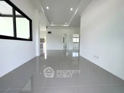Spacious modern living room with glossy tiled floors and recessed lighting