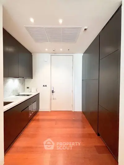 Modern kitchen with sleek cabinetry and hardwood floors in luxury apartment