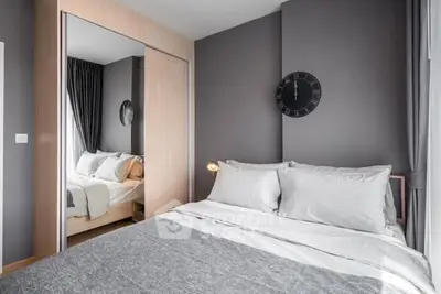 Modern bedroom with stylish decor and mirrored wardrobe