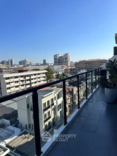 Stunning cityscape view from a modern balcony with sleek railing and potted plants.