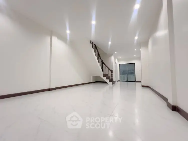 Spacious modern living room with elegant staircase and bright lighting