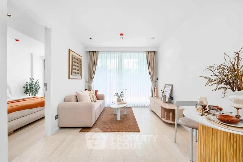Modern living room with elegant decor and natural light, adjacent to a cozy bedroom.
