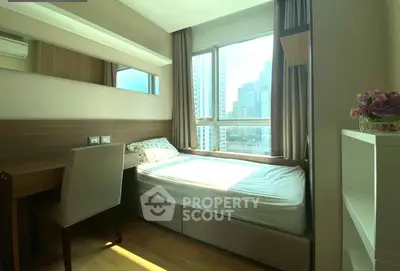 Cozy bedroom with city view, modern furniture, and ample natural light.