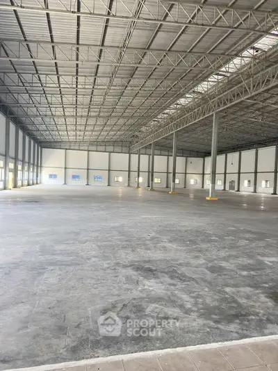 Spacious industrial warehouse with high ceilings and ample natural light, perfect for large-scale operations.