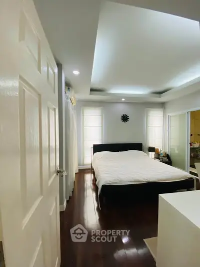 Spacious bedroom with modern design and natural light, featuring a comfortable bed and elegant decor.