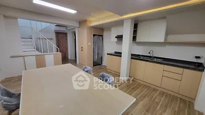 Modern kitchen with wooden flooring and sleek cabinetry in open layout apartment
