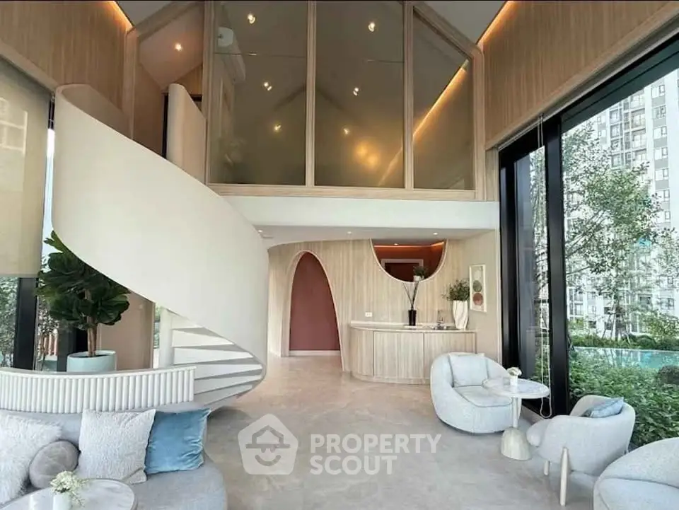 Luxurious modern living room with spiral staircase and floor-to-ceiling windows offering stunning views.
