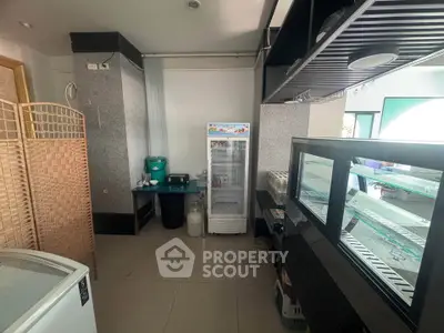 Spacious commercial kitchen with modern appliances and ample storage space.