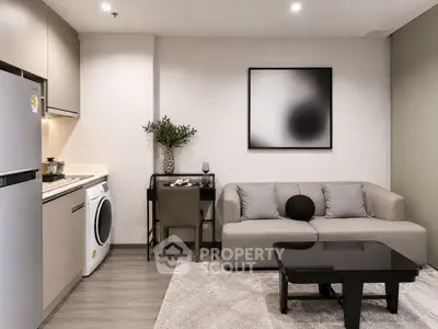 Modern living room with stylish decor, featuring a washing machine and sleek furniture in a cozy apartment.