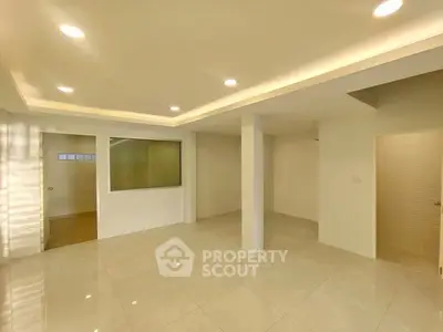 Spacious modern living room with recessed lighting and tiled flooring