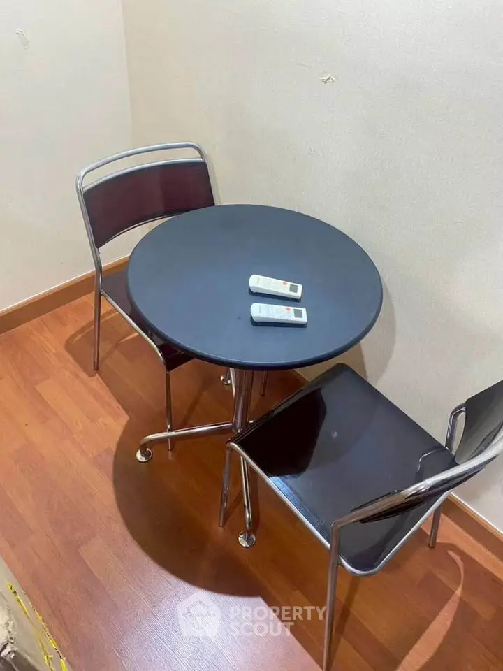 Cozy corner with modern table and chairs on wooden flooring, perfect for intimate gatherings.