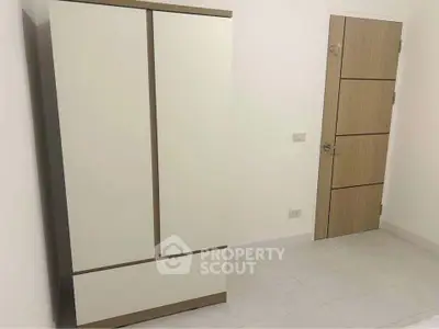 Minimalist bedroom with sleek wardrobe and modern door design.