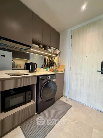 Modern kitchen with sleek appliances and stylish cabinetry in a compact layout.