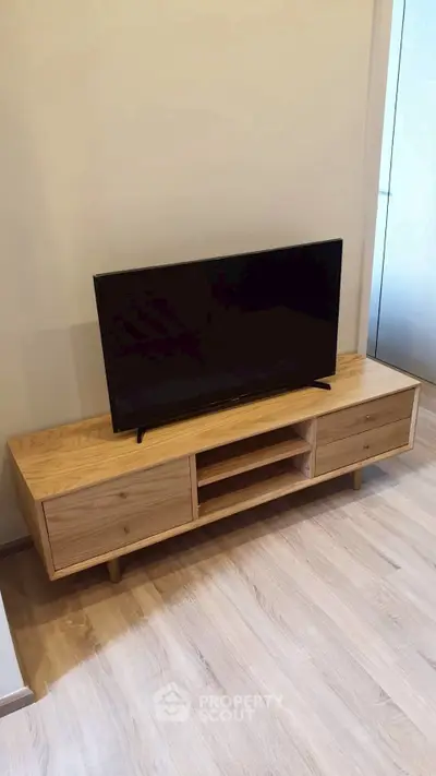 Modern living room with sleek wooden TV stand and flat-screen TV