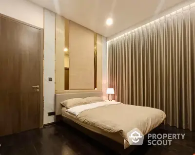 Elegant bedroom with rich wooden flooring, modern furnishings, and ambient lighting, perfect for a restful retreat in a luxurious home.