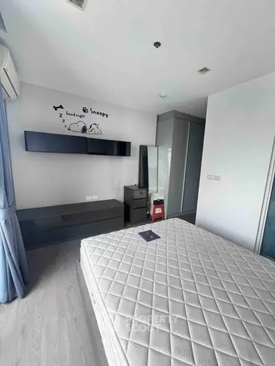 Modern bedroom with minimalist decor and large window for natural light.