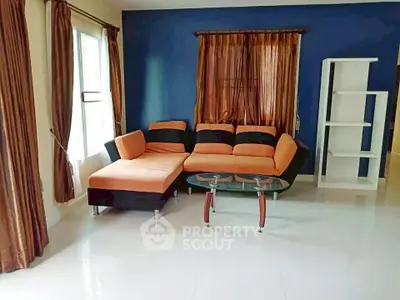 Spacious living room with modern orange sofa and glass coffee table