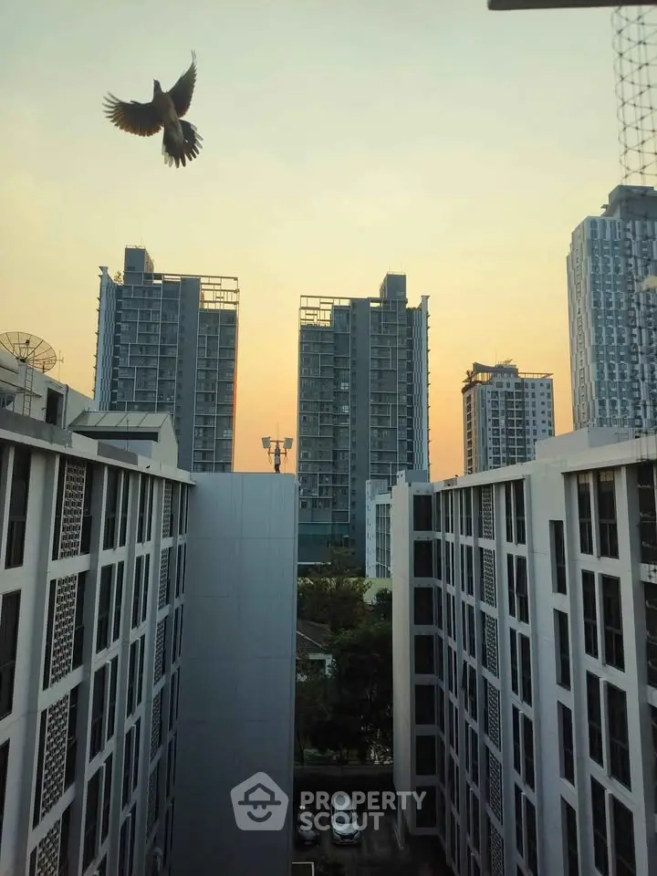 Stunning urban view from a high-rise building at sunset, showcasing modern architecture and city skyline.