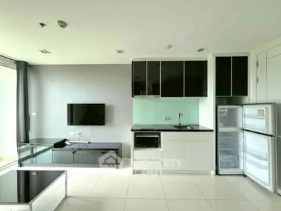 Modern open-plan kitchen with sleek black and white cabinetry and integrated appliances.