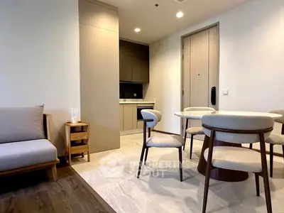 Modern open-plan living and dining area with stylish furniture and sleek kitchen design.