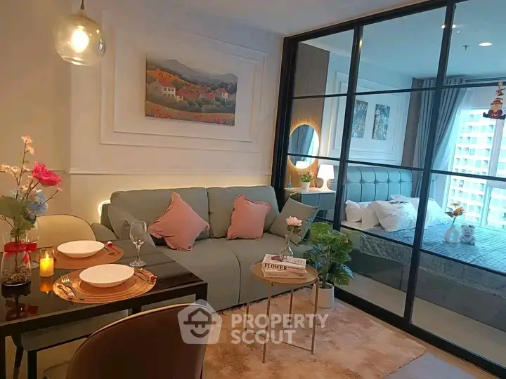 Modern open-plan living room with cozy bedroom separated by glass partition, stylish decor and natural light.