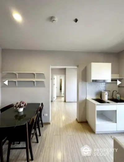 Modern kitchen with dining area and sleek cabinetry in open layout apartment