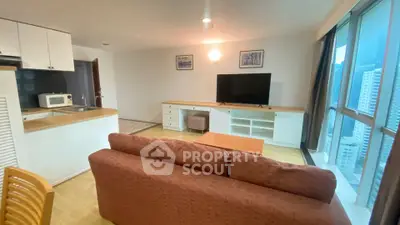 Spacious living room with modern furniture and large windows offering city views.