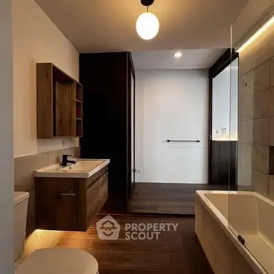 Modern bathroom with sleek wooden accents and elegant lighting