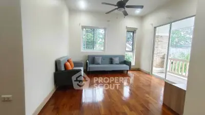 Spacious living room with hardwood floors and large windows in a modern home