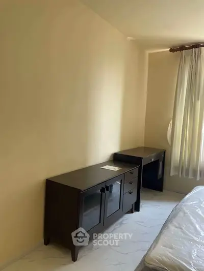 Spacious bedroom with elegant dark wood furniture and natural light