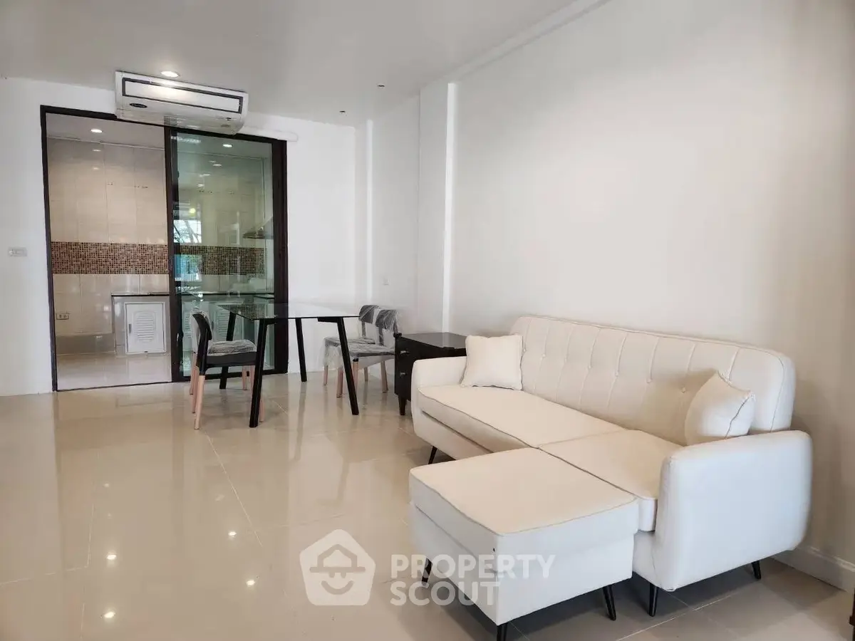 Modern living room with white sofa and dining area in open layout