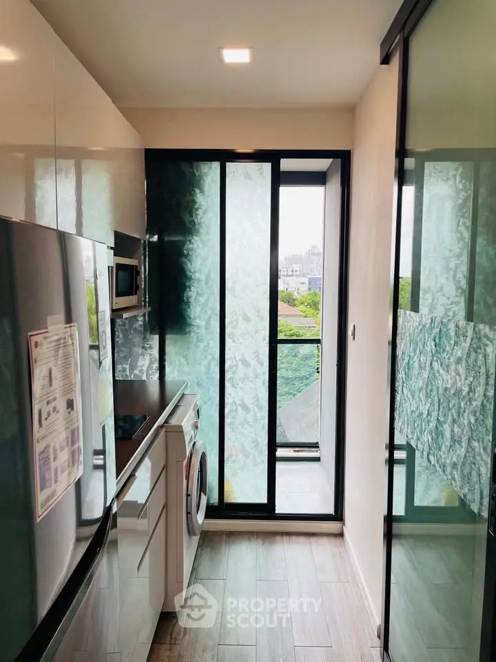 Modern kitchen with sleek appliances and large windows offering a scenic view, perfect for urban living.