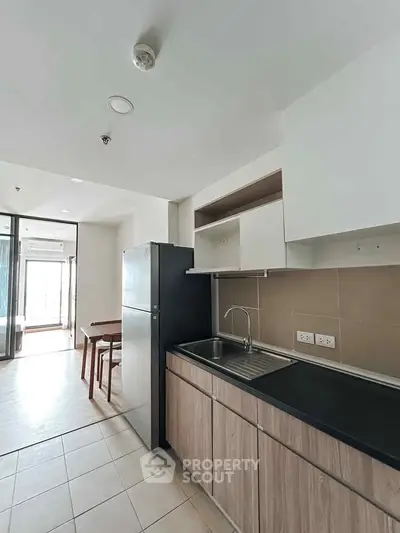 Modern kitchen with sleek cabinetry and dining area in a bright apartment