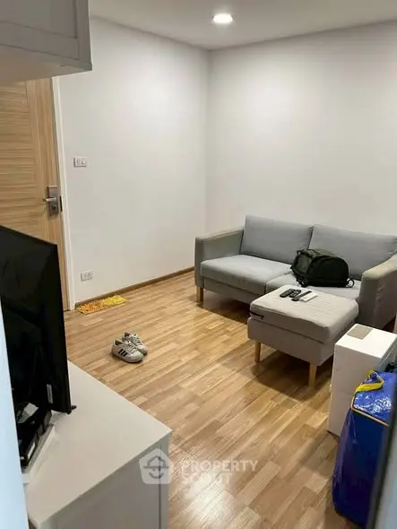 Cozy living room with modern sofa and wooden flooring, perfect for relaxation.