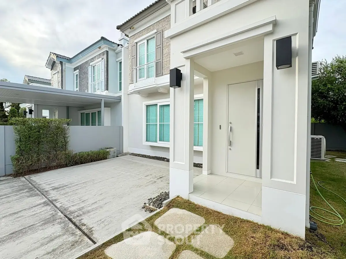 Modern two-story house with spacious driveway and elegant entrance in a serene neighborhood.