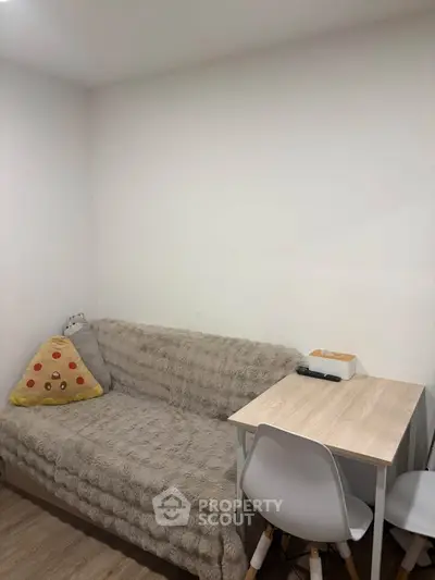 Cozy small living area with plush sofa and compact dining table, perfect for urban living.