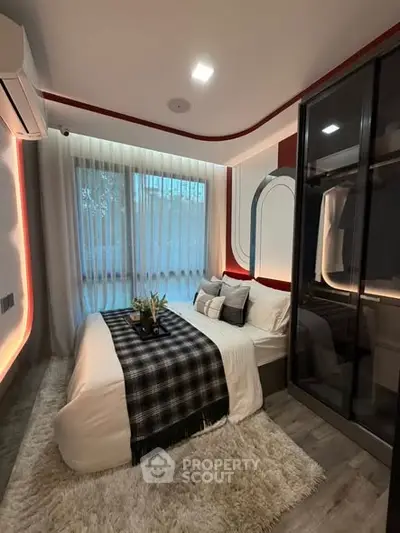 Modern bedroom with stylish decor, large window, and cozy ambiance.