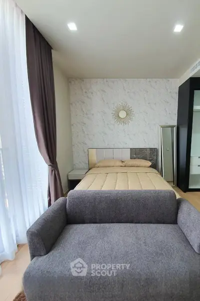 Modern bedroom with stylish decor and cozy ambiance, featuring a plush bed and elegant curtains.