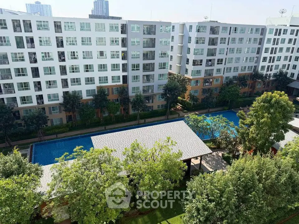 Modern apartment complex with pool and lush greenery, offering a serene urban living experience.