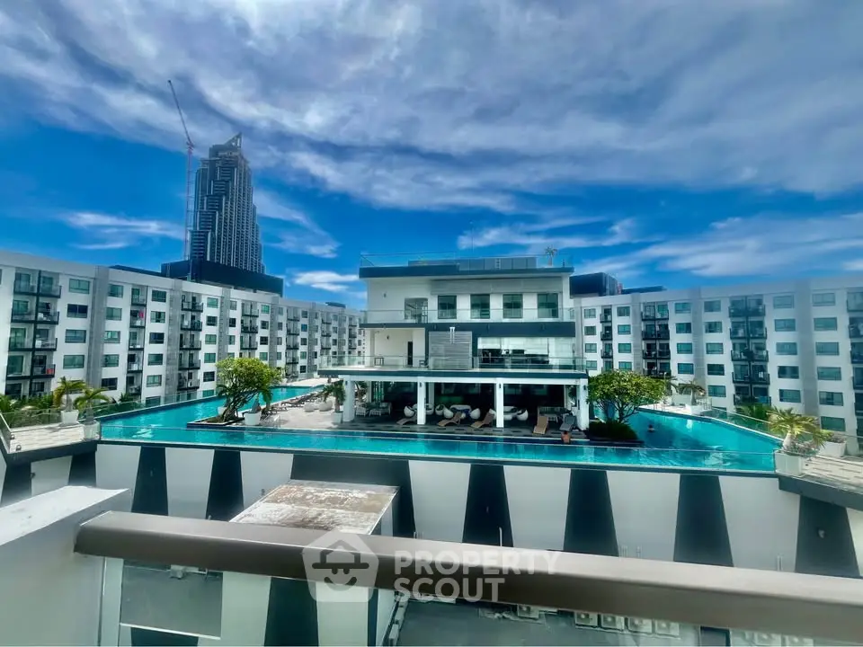 Luxurious apartment complex with stunning rooftop pool and city skyline view.