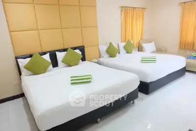 Spacious bedroom with two large beds and modern decor, perfect for comfort and relaxation.