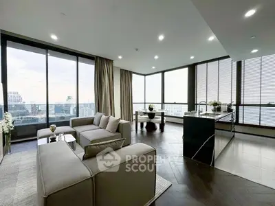Luxurious corner unit living room with panoramic city views and modern open kitchen.