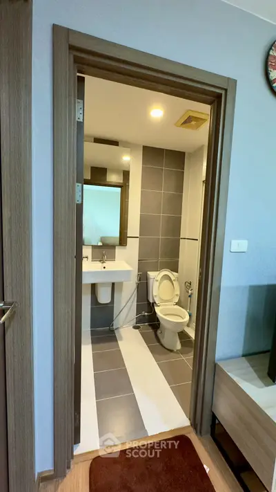 Modern bathroom with sleek design and neutral tones, featuring a spacious layout and contemporary fixtures.