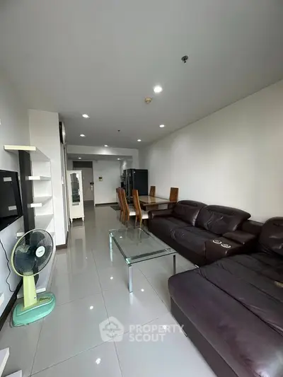 Spacious living room with modern furniture and open layout in a stylish apartment.
