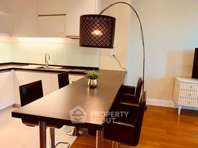 Modern kitchen with sleek black countertop and stylish lighting