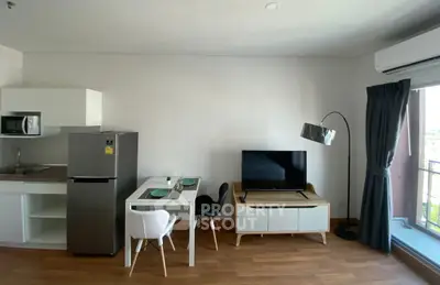 Modern apartment interior with sleek kitchen and cozy living area, featuring stylish furniture and natural light.