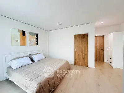 Spacious modern bedroom with minimalist decor and wooden accents