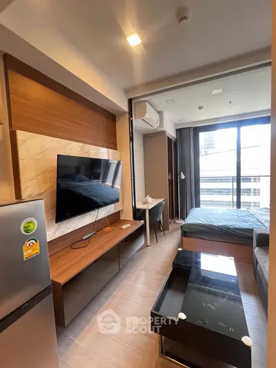 Modern studio apartment with sleek furnishings and large windows offering city views.