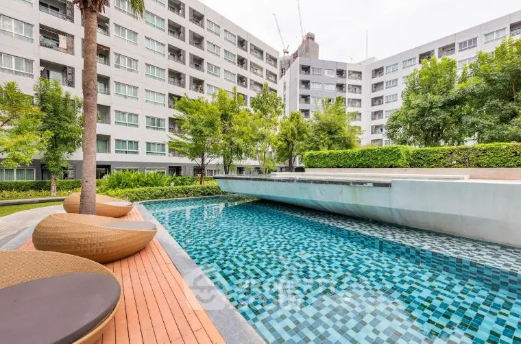 Modern condominium with stylish pool and lush greenery, perfect for urban living.